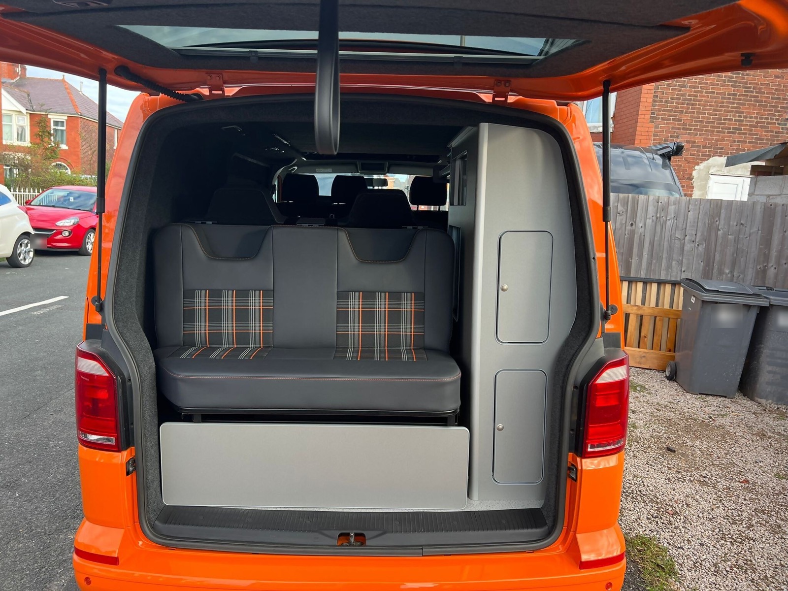 Orange van with the boot open to reveal the seating