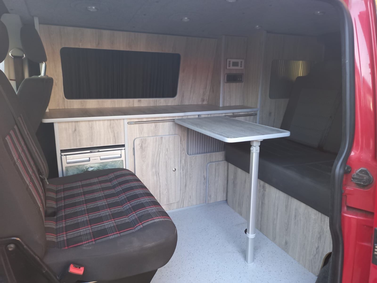 Kitchen units and a table inside the red van conversion